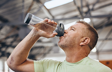 Image showing Man, fitness and drinking water bottle for detox after workout, exercise or cardio training indoors. Sporty male with drink in hydration or healthy endurance, recovery or thirst for sports exercising