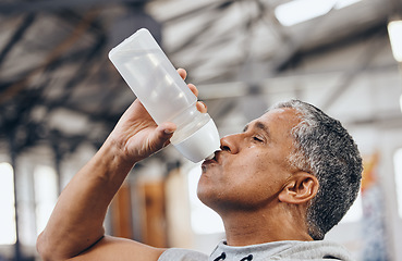 Image showing Man, fitness and drinking water bottle for hydration after workout, exercise or cardio training indoors. Sporty male staying hydrated for healthy endurance, recovery or thirst from sports exercising