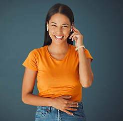 Image showing Woman, happy portrait and listening to music online while streaming on a studio background. Smile of a young gen z person with wireless earphones for funny podcast, radio or audio to relax on blue