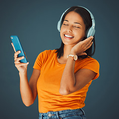 Image showing Radio, headphones and woman listening to music on phone or mobile app isolated against a studio background. Fun, sound and female enjoying and streaming a podcast or audio smiling and happy