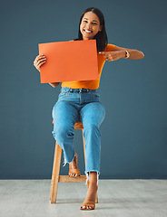 Image showing Woman, poster portrait and pointing at mockup banner space for sale, discount or promotion. Happy model with advertising for product placement, logo or branding on billboard or orange paper in studio