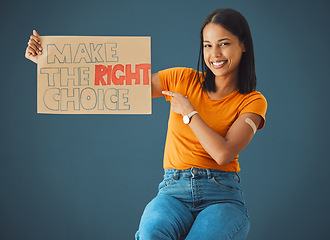 Image showing Black woman, portrait and pointing at protest poster, stop covid or vaccine opinion in healthcare. Happy gen z girl, billboard or wellness choice with plaster, cardboard sign and safety by blue wall