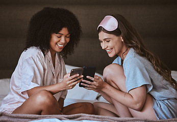 Image showing Woman, friends and phone on bed with smile for social media, networking or funny meme in sleepover at home. Happy women smiling, laughing or relaxing with smartphone entertainment in the bedroom