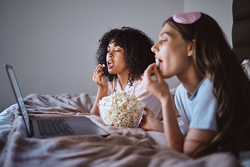 Image showing Laptop, movie and relax with friends and popcorn in bedroom for sleepover, bonding and streaming. Technology, internet and online with women at night for cinema, subscription and film entertainment