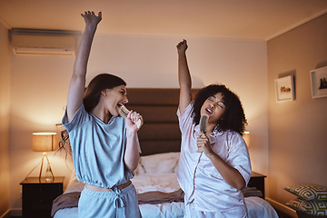 Image showing Friends, singing with brush and women in pajamas to get ready for girls night out dancing, fun music concert and happiness. Girl, friend and happy smile, girlfriends karaoke at sleepover in bedroom.