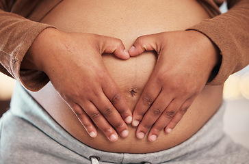 Image showing Pregnant woman, closeup of heart hands on belly and happy black mother alone in Jamaica living room. Excited future parent, holding healthy abdomen at home and loving mommy in pregnancy care