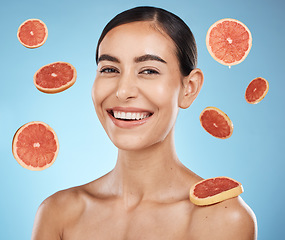 Image showing Woman, studio portrait and grapefruit with beauty skincare, smile or happy for wellness by blue background. Young gen z model, healthy face skin or citrus fruit for vitamin c with self care happiness