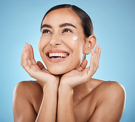 Image showing Beauty cream, skincare and happy face of a woman with hands for dermatology, cosmetics and glow. Aesthetic model with spa natural facial self care for health and wellness on a blue background