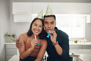 Image showing Happy, birthday celebration and portrait of a couple with party hats in a kitchen. Love, care and Asian woman with a man together in a home with happiness to celebrate holiday in a house on date