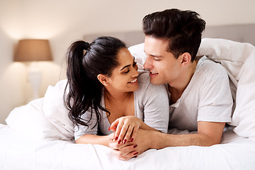 Image showing Bedroom, love and interracial couple together in home holding hands at night. Smile diversity and marriage of an Indian woman and man with love, care and relax happiness with a smile in a house