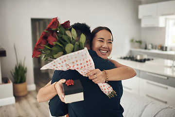 Image showing Couple hug, home and roses present surprise of an Asian woman on valentines day. Living room, rose bouquet and lounge of people with love, care and happiness together with a smile from present