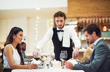 Image showing Couple, restaurant server and fine dining at table for valentines day date, bonding and romance in night. Man, woman and waiter with food, service and hospitality for dinner, love and celebration