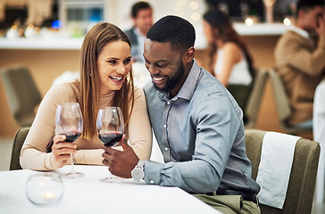 Image showing Cheers, love and couple on a date in a restaurant for valentines day, romantic event or anniversary. Happy, smile and interracial man and woman drinking wine, talking and bonding at a luxury dinner.