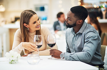 Image showing Love, wine and interracial couple on date for fine dining, restaurant or valentines celebration together. Black man and happy woman with romance alcohol glasses, celebrate and luxury in night bokeh