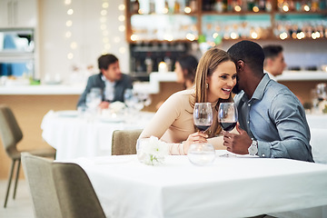 Image showing Restaurant date, couple and wine celebration of a man telling a secret at a dinner table. Anniversary celebration, valentines day smile and wine at night with love, care and conversation together