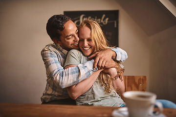 Image showing Love, couple and quality time at a cafe, hug and happiness together, romance and celebrate achievement. Valentines day, man and woman with smile, romantic and in coffee shop for break, relax or happy