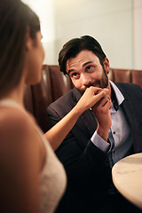 Image showing Hand, kiss and love with a couple in a restaurant on a date night out together for fine dining or luxury. Love, romance and affection with a man kissing his wife while dating in celebration