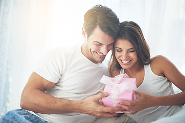 Image showing Love, gift and valentines day with a couple in a bedroom of their home together for a romantic celebration. Birthday, box or present with a young man and woman bonding in bed to celebrate in a house