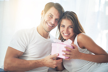 Image showing Portrait, gift and valentines day with a couple in bed together at home for a romantic celebration. Love, box or present with a man and woman in the bedroom of a house for a birthday or anniversary