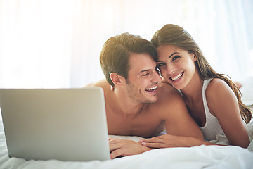 Image showing Laptop, happy and couple lying in bed together while watching a online movie or video at their home. Happiness, smile and portrait of a woman browsing the internet on computer with husband in bedroom