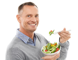 Image showing Portrait, food and diet with a man in studio isolated on a white background eating vegetables for health. Green, nutrition and health with a mature male indoor to eat an organic salad for wellness