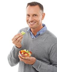 Image showing Happy man with fruit salad isolated on a white background for healthy green lunch, diet choice or nutritionist breakfast. Professional vegan person or model eating fruits, food or apple in studio