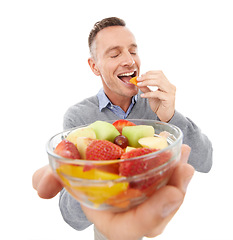 Image showing Happy man eating fruits isolated on a white background for healthy green lunch, diet offer or nutritionist breakfast. Professional vegan person or model giving fruits salad, food or peach in studio