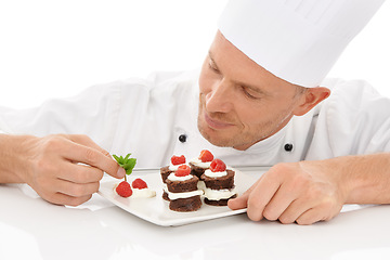 Image showing Baking, presentation and chef with a dessert for catering isolated on a white background. Cooking, professional and man plating a chocolate cake and fruit on a plate for service on a backdrop