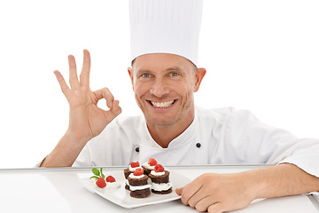 Image showing Perfect, sign and dessert chef happy with dish or sweet chocolate flavor with hand gesture isolated in studio white background. Portrait, smile and plate of food by a culinary cook with mini cakes