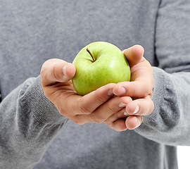 Image showing Hand, health and man in a studio with a apple for nutrition, diet and a healthy snack with vitamins. Wellness, natural and healthy male person with fresh, organic and raw green fruit for a craving.