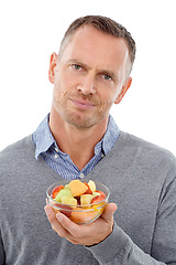 Image showing Portrait, fruit salad and unhappy with a mature man in studio isolated on a white background for health eating. Face, food and upset with an annoyed male on blank space feeling negative about a diet