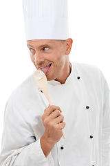 Image showing Man licking spoon, chef uniform and goofy bakery owner and small business in restaurant industry isolated on white background. Happy cafe, discount deal and delicious menu special promotion in studio