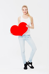 Image showing Portrait, heart and valentines day with a woman in studio on a gray background for love, dating or romance. Red, date and romantic with a female holding an emoji, icon or symbol on blank space