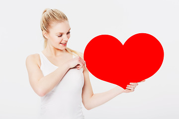 Image showing Valentines day, happy and woman with a heart in a studio with a smile for a romantic gesture. Happiness, excited and female model from Australia holding a love shape isolated by a white background.