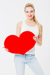 Image showing Valentines day, portrait and woman with a heart in a studio with a smile for a romantic gesture. Happiness, excited and female model from Australia holding a love shape isolated by a white background