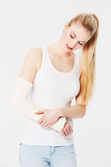 Image showing Injury, pain and woman with a broken arm after an accident isolated on a white background. Hurt, handicap and girl holding an injured and bandaged limb for an emergency in a brace on a backdrop