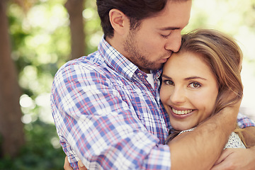 Image showing Happy couple hug, bonding or forehead kiss on love date, valentines day or romance nature break, park or relax garden. Woman, smile or man kissing head in trust, security embrace or thank you support