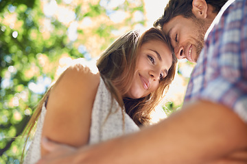 Image showing Love, nature and couple hug in park with trees while on romantic date for valentines day, from below. Romance, relationship and man with woman in garden together with happy smile and loving touch.