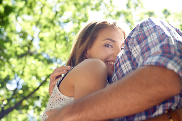 Image showing Love, forest and woman hugging man in park with nature while on romantic date for valentines day, low angle. Romance, relationship and couple in garden together with happy smile and loving touch.