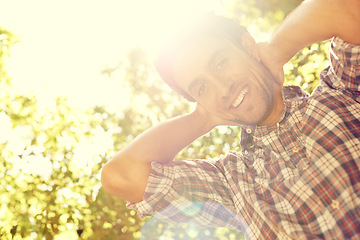 Image showing Sun, man and portrait in an outdoor park with lens flare from sunshine in summer. Happy, smile and nature with a young person by trees feeling relax, calm and positive on a sunny day in a garden