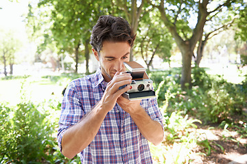 Image showing Photography, photo and man with a vintage camera in nature for creativity and hobby in France. Creative, artistic and photographer taking pictures in a park of the natural environment and ecology