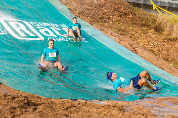 Image showing Athletes sliding to mud and water