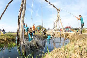 Image showing Athletes go through mud and water