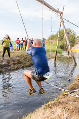 Image showing Athlete go through mud and water