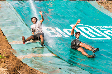 Image showing Athletes sliding to mud and water