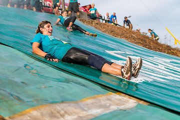 Image showing Athletes sliding to mud and water