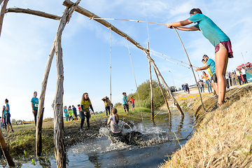 Image showing Athletes go through mud and water