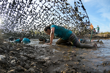 Image showing Athletes crawling through mud