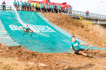 Image showing Athletes sliding to mud and water