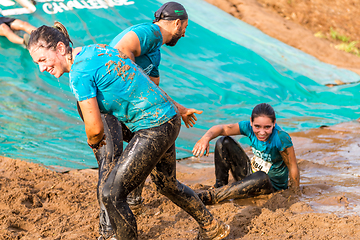 Image showing Athletes sliding to mud and water